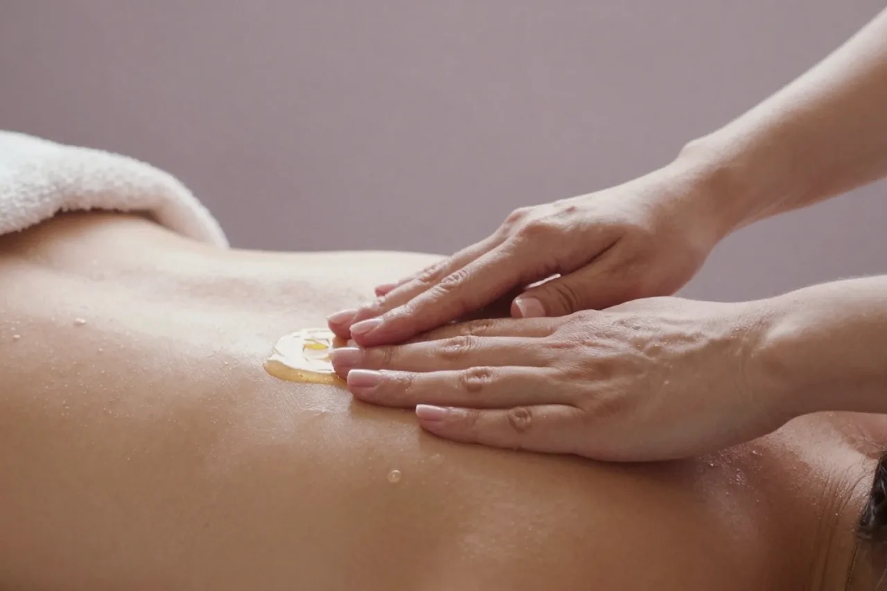 Massage des mains à l'huile dans une lumière mauve